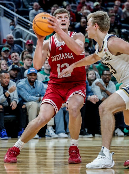 Indiana Hoosiers forward Miller Kopp (12) shoots past Notre Dame's Dane Goodwin (23) during the Crossroads Classic college basketball tournament on Saturday, Dec. 18, 2021, at Gainbridge Fieldhouse in Indianapolis. The Notre Dame Fighting Irish took on the Indiana Hoosiers.