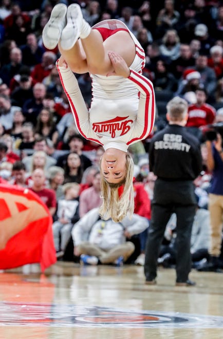 A IU cheerleader does a back flip during the Crossroads Classic college basketball tournament on Saturday, Dec. 18, 2021, at Gainbridge Fieldhouse in Indianapolis. The Notre Dame Fighting Irish took on the Indiana Hoosiers.